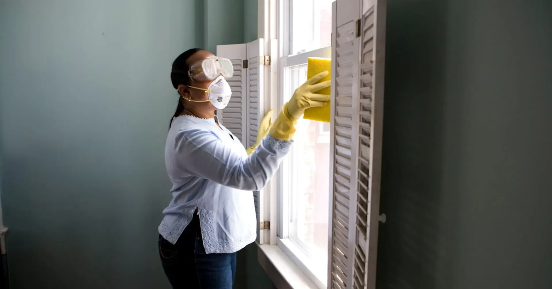 Pest control technician applying spider treatment around an Adelaide home